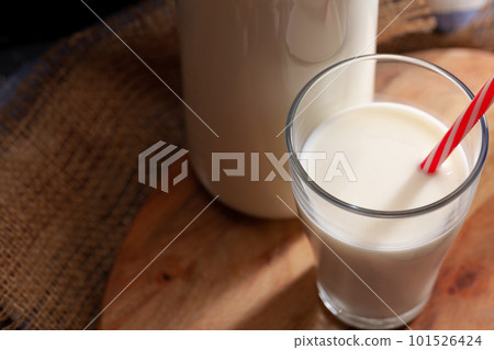 Glass and bottle of milk on wooden board close up Glass and bottle of milk on wooden board close up 101526424