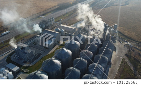 Grain elevator. Granary. Large metal structure grain elevator. Storage facility for grain. Top view. Grain storage. Silos. Metal hangar for cereal. Modern new elevator plant. agricultural agribusiness Grain elevator. Granary. Large metal structure grain elevator. Storage facility for grain. Top view. Grain storage. Silos. Metal hangar for cereal. Modern new elevator plant. agricultural agribusiness 101528563