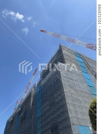 A construction site and a huge crane in front of the Ibaraki City Hall in the blue sky A construction site and a huge crane in front of the Ibaraki City Hall in the blue sky 101528569
