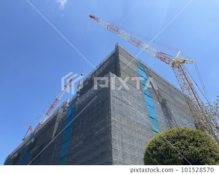 A construction site and a huge crane in front of the Ibaraki City Hall in the blue sky 101528570
