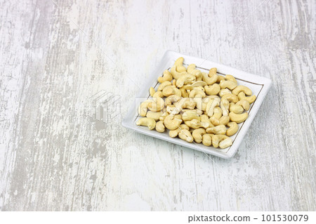 Unglazed cashew nuts on a white plate. Unglazed cashew nuts on a white plate. 101530079