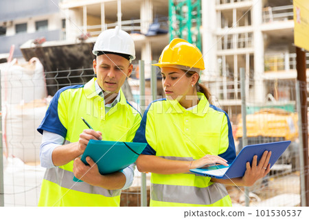 Man and woman engineers in construction site 101530537