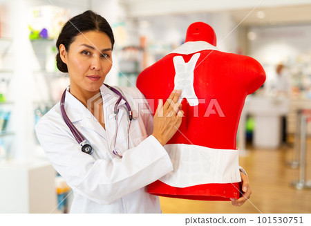 Woman doctor in drugstore with mannequin 101530751