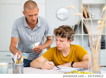 Father giving son money 101530812