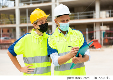 Civil engineers in masks checking work process 101530919