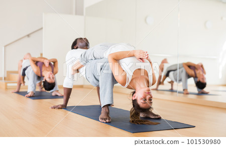 Woman practicing yoga with partner at studio 101530980