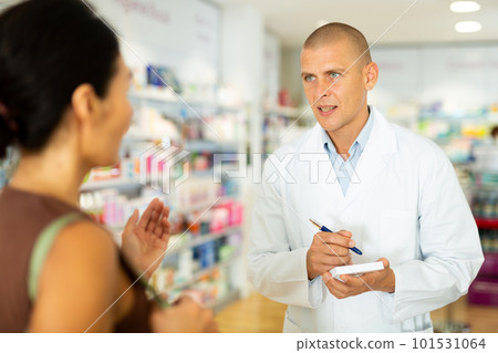 Pharmacist writes in notebook name of the drugs that the buyer tells him to Pharmacist writes in notebook name of the drugs that the buyer tells him to 101531064