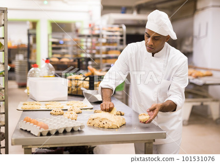 Baker at work - making sweet buns with dough 101531076
