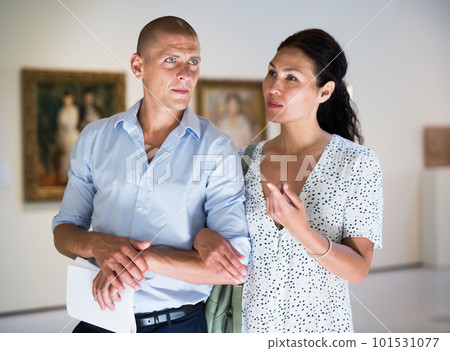 Woman and man watching exposition of paintings Woman and man watching exposition of paintings 101531077