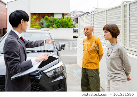 一對老年夫婦在戶外聽汽車銷售員講解 一對老年夫婦在戶外聽汽車銷售員講解 101531590