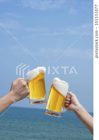 Cheers with beer in front of the blue sky and the sea 101531877