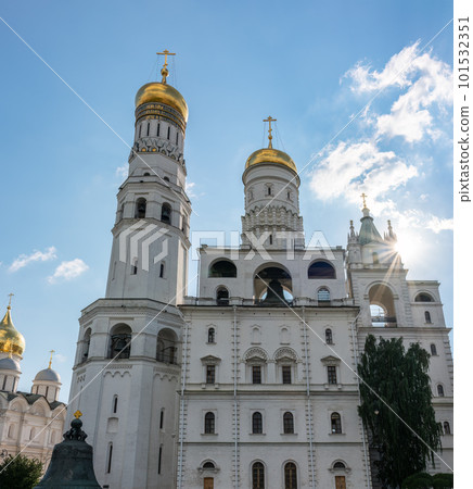 Ivan the Great Bell Tower, with Assumption Belfry on the right in Moscow Kremlin. Blue sky background with sunbeams 101532351