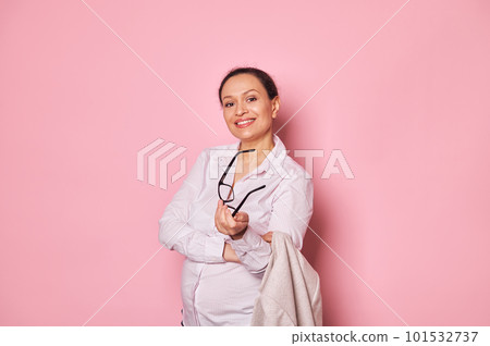 Confident portrait of middle-aged multi-ethnic smiling pregnant woman with arms folded, looking at camera, isolated on pink background. People, pregnancy, maternity leave, career and business concept 101532737
