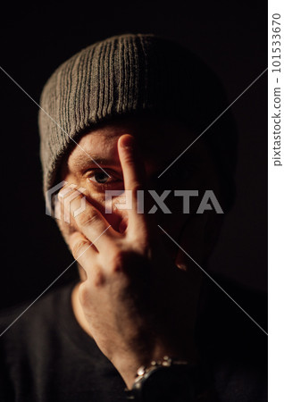 Serious dramatic man looking away while standing against black studio background Serious dramatic man looking away while standing against black studio background 101533670
