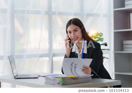 Asian Business person makes analysis and research financial report and talking with client by phone, analyzes profits. Accountant checks status of financial Asian Business person makes analysis and research financial report and talking with client by phone, analyzes profits. Accountant checks status of financial 101534313