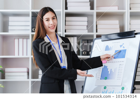 Smiling Asian Business person makes financial report and studies annual figures, analyzes profits. Accountant checks status of financial Smiling Asian Business person makes financial report and studies annual figures, analyzes profits. Accountant checks status of financial 101534314
