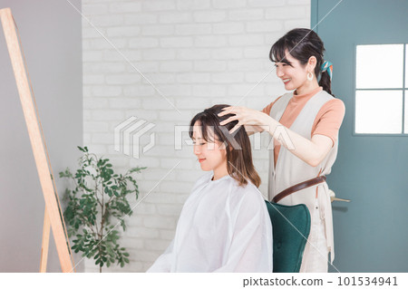 美髮師/理髮師亞洲女性,為來美容院/美髮沙龍的顧客提供頭部水療/按摩 美髮師/理髮師亞洲女性,為來美容院/美髮沙龍的顧客提供頭部水療/按摩 101534941