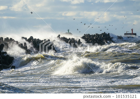 Coastal storm in the Baltic Sea, big waves crash against the harbor breakwater, breaking wave 101535121