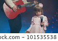 Little girl on stage in vintage dress, she sings into microphone and dances, her father plays acoustic guitar. Color music is shining and smoke is billowing. Father and Child Day, performance on stage 101535538