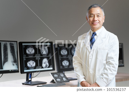 一位身穿白大褂的老人站在顯示器前,目光一轉 一位身穿白大褂的老人站在顯示器前,目光一轉 101536237