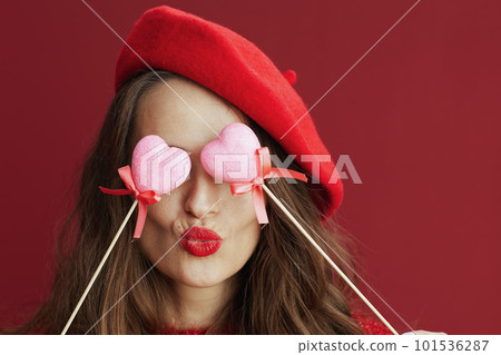 stylish female in red sweater and beret sending kiss 101536287