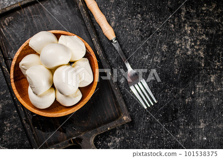 Mozzarella cheese on a cutting board with salt. 101538375
