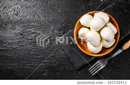 Mozzarella cheese in a wooden plate on the table. Mozzarella cheese in a wooden plate on the table. 101538412