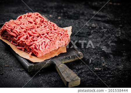 A piece of raw minced meat on a cutting board. 101538444