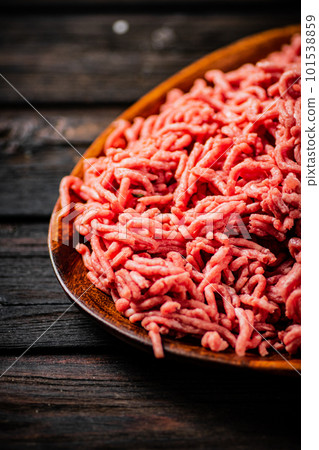 A wooden plate full of minced meat. 101538859