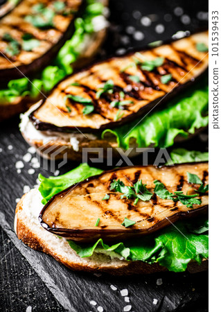 Grilled eggplant sandwich on a stone board. 101539433