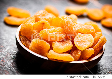 Full wooden plate with dried apricots. 101539590