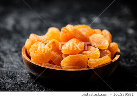Delicious dried apricots in a wooden plate. Delicious dried apricots in a wooden plate. 101539591
