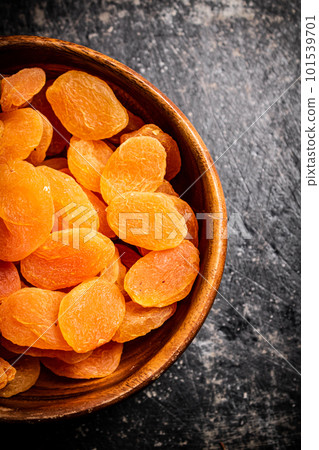 Delicious dried apricots in a wooden plate. 101539701
