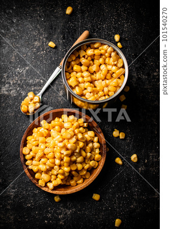 Canned corn on a wooden plate. 101540270