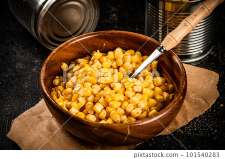 Canned corn on a wooden plate. 101540283