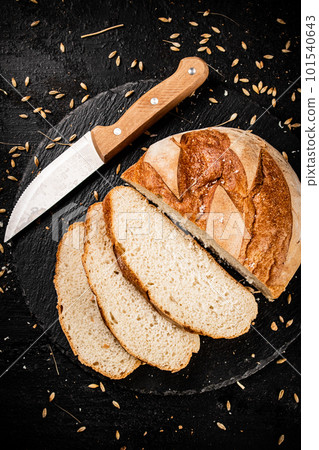 Sliced on a stone board wheat bread with grains. 101540643