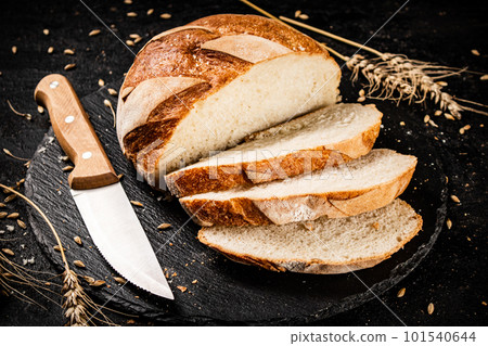 Sliced on a stone board wheat bread with grains. 101540644