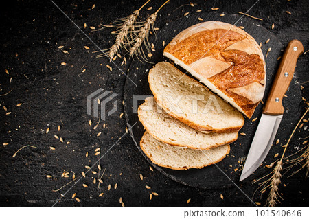 Sliced on a stone board wheat bread with grains. 101540646