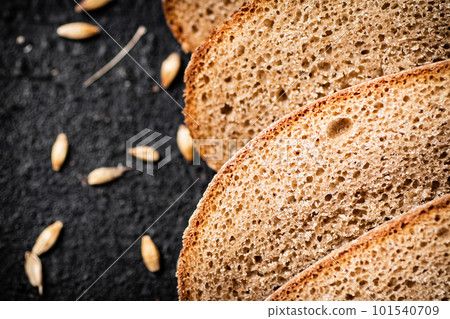 Slices of rye bread with grain on the table. 101540709