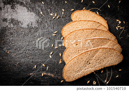 Slices of rye bread with grain on the table. 101540710