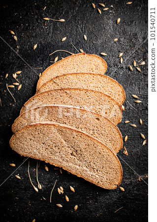Slices of rye bread with grain on the table. 101540711