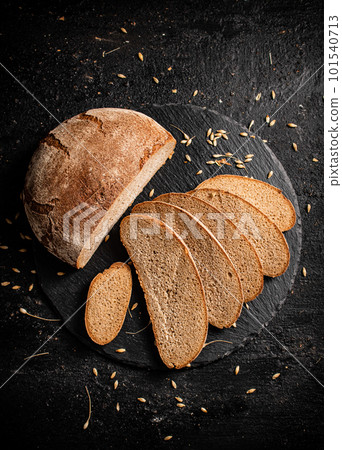 Slices of fresh bread on a stone board. 101540713