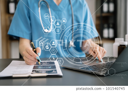 Doctor working with laptop computer and writing on paperwork. Doctor working with laptop computer and writing on paperwork. 101540745