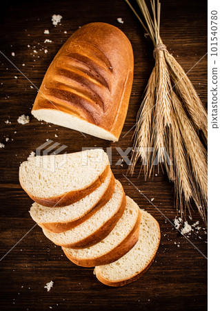 Sliced wheat bread. On a wooden background. 101540780