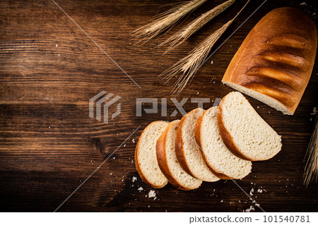 Sliced wheat bread. On a wooden background. 101540781