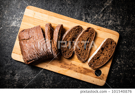 Sliced rye bread on a cutting board. 101540876