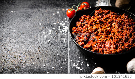 Bolognese sauce on a stone board with spices, garlic and tomatoes. Bolognese sauce on a stone board with spices, garlic and tomatoes. 101541633