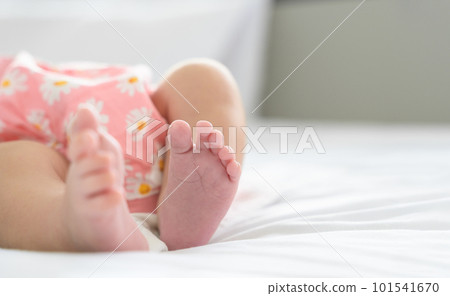 Cute little newborn baby feet on bed at home. Selective focus. Cute little newborn baby feet on bed at home. Selective focus. 101541670