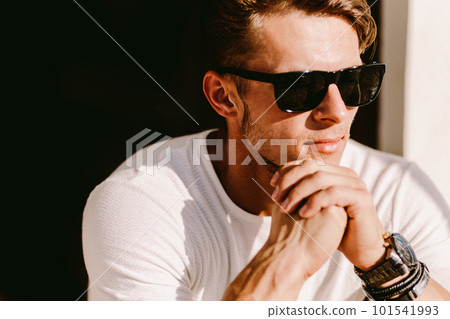 portrait of a brutal man in sunglasses and watch outdoors portrait of a brutal man in sunglasses and watch outdoors 101541993