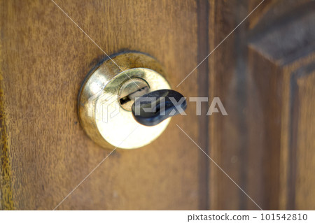 Door handle with inserted key in the keyhole. The door lock with the handle and a key. House key with a house key. Out of focus Door handle with inserted key in the keyhole. The door lock with the handle and a key. House key with a house key. Out of focus 101542810